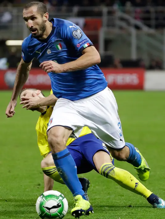 Pemain Italia, Giorgio Chiellini merebut bola dari pemain Swedia, Marcus Berg pada laga leg kedua playoff Piala Dunia 2018 di Stadion San Siro, Selasa (14/11). Swedia lolos ke Rusia 2018 berkat keunggulan agregat 1-0. (AP/Luca Bruno)