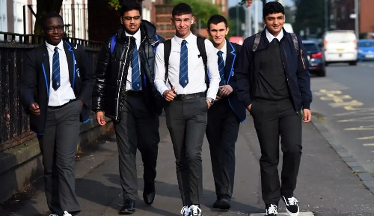 Pelajar Holyrood Secondary School saat kembali bersekolah di tengah pelonggaran lockdown akibat pandemi virus corona (Covid-19) di Glasgow, Skotlandia, Rabu (12/8/2020). Sebelumnya mereka diliburkan akibat penyebaran wabah pandemi yang melanda Skotlandia sejak Maret lalu.  (AFP/ANDY BUCHANAN)