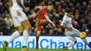 Pemain Liverpool, James Milner (tengah) melakukan tembakan melewati dua pemain Swansea City pada lanjutan Liga Premier Inggris antara Liverpool vs Swansea City di Stadion Anfiled, Senin (30/11/2015) dini hari WIB. (AFP Photo/Paul Ellis)