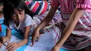 Anak-anak korban gempa tsunami Palu sedang mewarnai di halaman kantor Dinas Sosial Palu, Sulawesi Tengah, Sabtu (6/10). Trauma healing diberikan untuk mencegah anak memiliki kepribadian buruk. (Liputan6.com/Fery Pradolo)