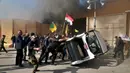 Para demonstran merusak mobil di dalam kompleks kedutaan besar AS, di Baghdad, Irak, Selasa (31/12/2019). Ribuan demonstran menyerbu kompleks Kedutaan Besar Amerika Serikat (Kedubes AS) di Baghdad, Irak menghancurkan pintu utama dan membakar area penerimaan tamu. (AP Photo/Khalid Mohammed)