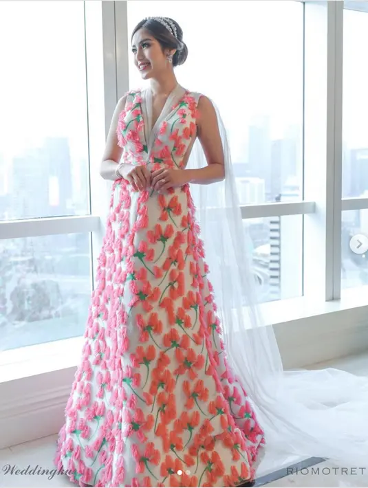 Jessica Iskandar mengenakan gaun rancangan Sebastian Gunawan, salah satu designer ternama Indonesia. Dress yang dikenakan Jedar berwarna dasar putih dengan sentuhan bunga berwarna merah muda.