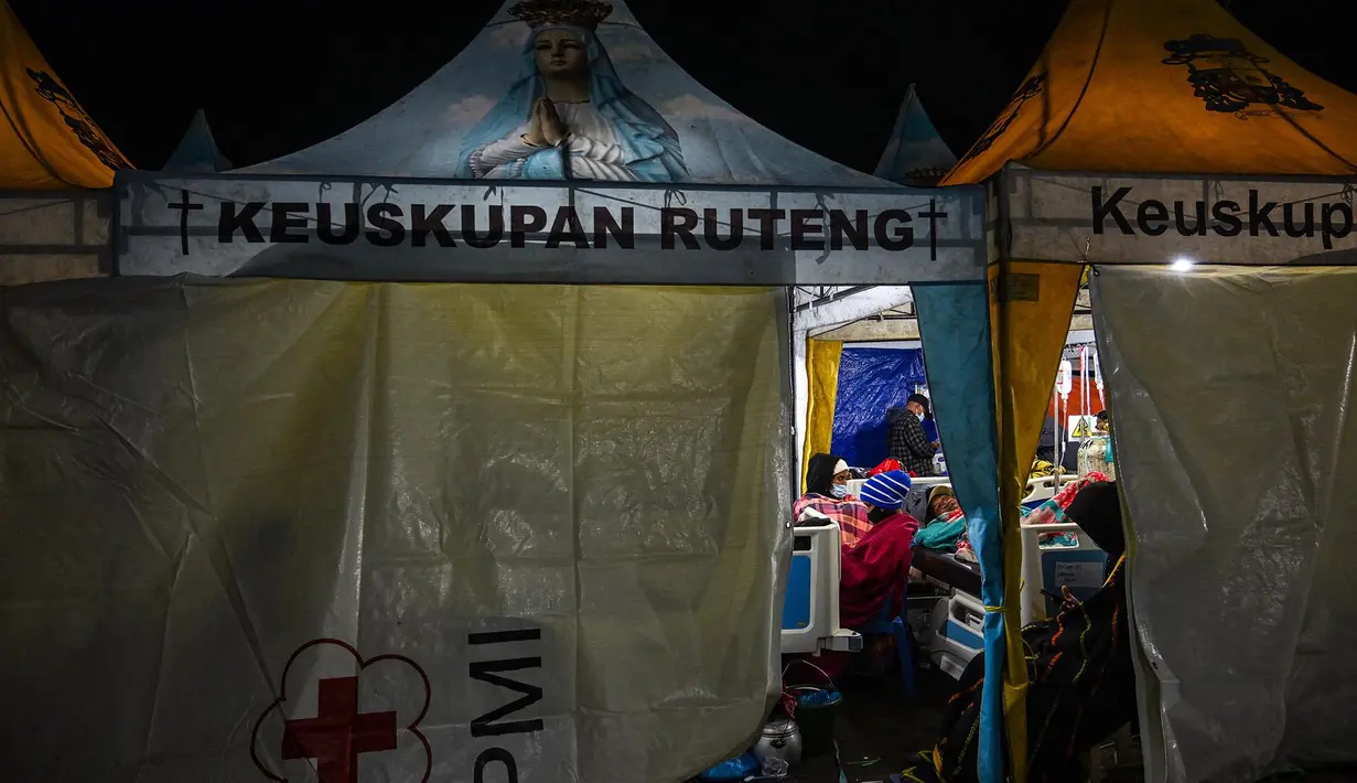 Kerabat menyaksikan para korban gempa bumi mendapatkan perawatan di tenda medis darurat di depan Rumah Sakit Ruteng di Ruteng, Manggarai, Nusa Tenggara Timur, Sabtu malam, 15 Agustus 2025. (AFP/ Juni Kriswanto)