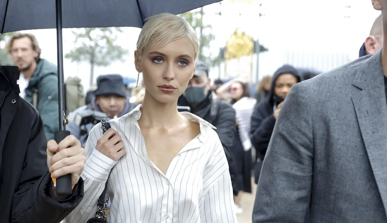 Iris Law tiba menghadiri acara busana ready-to-wear Spring/Summer 2023 Dior yang dipresentasikan di Paris, Selasa, 27 September 2022. Putri dari Jude Law ini memamerkan selera gayanya yang sensasional dalam balutan kemeja oversized bergaris yang diselipkan ke dalam celana beige dengan kawat gigi tergantung longgar di pinggangnya. (AP Photo/Lewis Joly)
