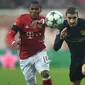 Gelandang Bayern Munchen, Douglas Costa, berebut bola dengan bek Atletico Madrid, Sime Vrsaljko. Munchen berhasil melepaskan empat kali tembakan ke arah gawang sementara Atletico melakukan tiga kali. (AFP/Christof Stache)