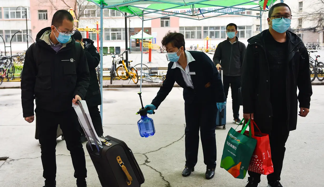 Staf mendisinfeksi koper mahasiswa di Universitas Teknologi Taiyuan, Taiyuan, Provinsi Shanxi, China, Jumat (10/4/2020). Gelombang pertama mahasiswa program sarjana, pascasarjana, dan doktor dengan tugas penelitian di Shanxi mulai kembali menjalani perkuliahan pada 10 April 2020. (Xinhua/Chai Ting)