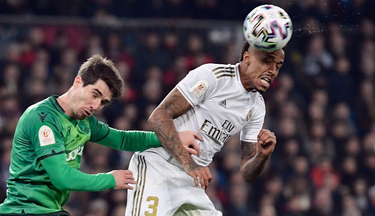 Pemain Real Sociedad, Aritz Elustondo (kiri) berebut bola dengan bek Real Madrid, Eder Militao pada laga perempat final Copa del Rey di Santiago Bernabeu, Kamis (6/2/2020). Real Madrid gagal melaju ke semifinal Copa del Rey setelah dibungkam Real Sociedad dengan skor 3-4. (JAVIER SORIANO/AFP)