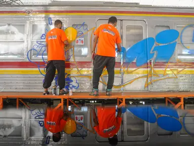 Seniman mural dan grafiti menggambar pada gerbong Kereta Rangkaian Listrik (KRL) Edukasi di Depo KRL, Depok, Jawa Barat, Kamis (29/8/2024). (merdeka.com/Arie Basuki)