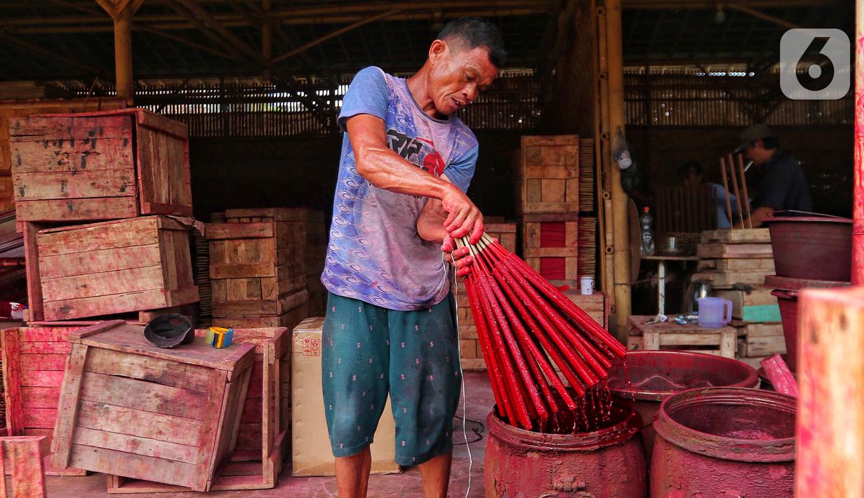 Seorang pekerja mewarnai hio dupa di sentra industri kecil pembuatan hio di Tangerang, Banten, Senin (9/1/2023). Jelang perayaan Imlek, pesanan hio dupa mengalami peningkatan untuk kebutuhan sembahyang. (Liputan6.com/Angga Yuniar)