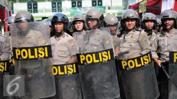 Personel Polres Tangerang Selatan memperagakan tindak penanganan kerusuhan yang dilakukan pengunjukrasa dalam simulasi pengamanan pilkada Tangerang Selatan di Polres Jakarta Selatan, Rabu (9/9/2015). (Liputan6.com/Gempur M Surya)