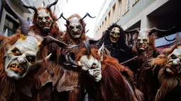 Sejumlah orang berkostum Krampuss selama parade di Munich, Jerman, Minggu (13/12). Dalam ceritanya Krampuss biasanya membawa cambuk hingga lonceng besar untuk menakut-nakuti anak-anak. (REUTERS/Michael Dalder)