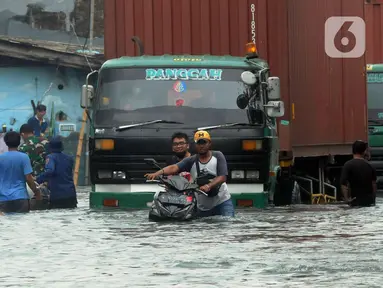Pengendara sepeda motor mendorong kendaraannya melewati banjir rob di kawasan Pelabuhan Sunda Kelapa, Jakarta, Selasa (7/12/2021). Banjir rob setinggi satu meter memutus Jalan Kerapu yang menghubungkan Ancol-Pluit. (merdeka.com/Arie Basuki)