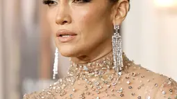 Aktris Jennifer Lopez berpose di pemutaran perdana film "Shotgun Wedding" di Los Angeles di TCL Chinese Theater di Hollywood, California (18/1/2023). Wanita 53 tahun itu Ikon mengenakan gaun krem tipis yang menutupi tubuhnya dan meninggalkan sedikit fisiknya yang menari-nari untuk imajinasi. (Emma McIntyre/Getty Images/AFP)