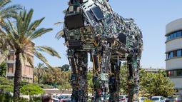 Seorang pengunjung melewati replika patung kuda troya "Cyber Horse" yang terbuat dari ribuan komputer dan komponen ponsel yang terinfeksi virus, di pintu masuk konferensi Cyber Week tahunan di Tel Aviv University, Israel, Senin (20/6). (Jack GUEZ/AFP)