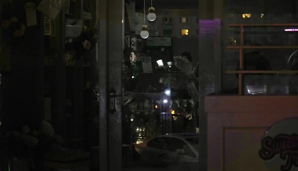 Seorang penjaga toko menggunakan lampu baterai di tokonya selama pemadaman listrik nasional, di Islamabad, Pakistan, Senin, 23 Januari 2023. Listrik padam di semua kota besar, termasuk di Karachi, Islamabad, Lahore dan Peshawar. (AP Photo/K.M. Chaudary)
