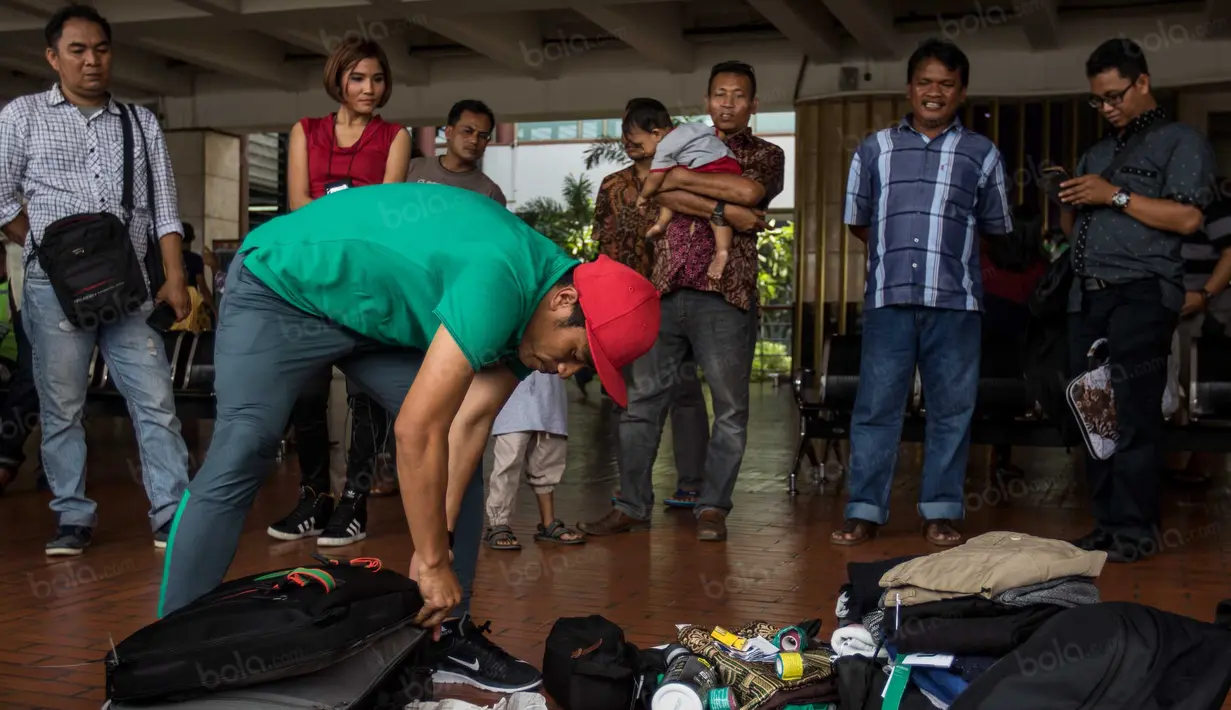 Akibat membongkar tas di pinggir jalanan bandara ini, Benny Wahyudi langsung menjadi tontonan warga yang melintas. (Bola.com/Vitalis Yogi Trisna)