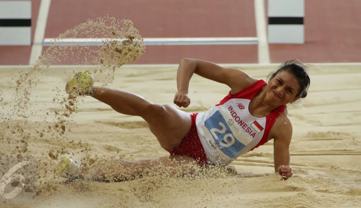 Atlet lompat jauh Indonesia, Maria Londa saat berhasil mendarat usai melakukan lompatan di nomor lompat jauh putri SEA Games 2015 di National Stadium, Singapura, Rabu (10/6/2015). Maria berhasil meraih emas. (Liputan6.com/Helmi Fithriansyah)