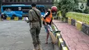 Petugas Satpol PP mengawasi warga yang menjalani sanksi sosial saat razia masker di kawasan Kota Tua, Jakarta, Kamis (24/2/2022). Perpanjangan PPKM level 3 untuk Jabodetabek berlaku selama sepekan, yakni sejak 22-28 Februari 2022 mendatang. (Liputan6.com/Faizal Fanani)