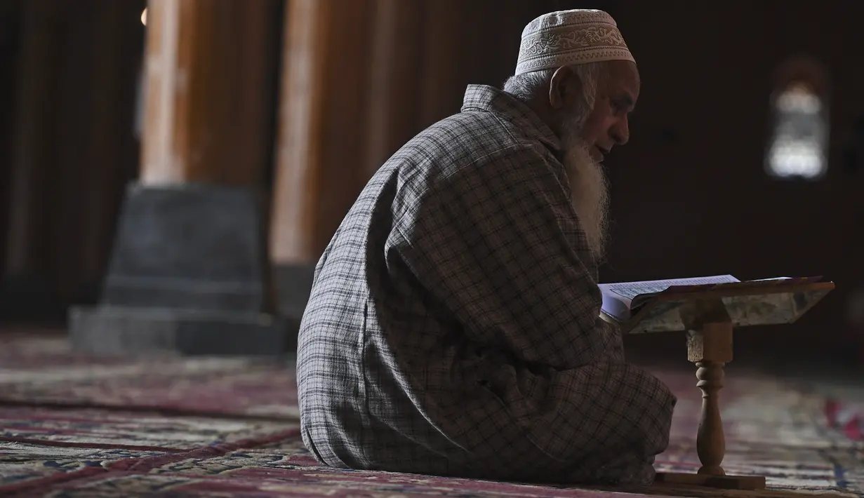 Seorang umat Muslim membaca Al-Quran selama bulan suci Ramadhan di dalam masjid Jamia di Srinagar (20/4/2021). Masjid Jamia Srinagar dianggap sebagai salah satu masjid terpenting di Kashmir. (AFP/ Tauseef Mustafa)