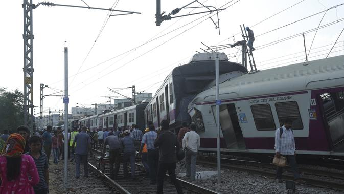 Sejumlah penumpang berjalan setelah kereta surburban yang bertabrakan dengan kereta ekspres antarkota di Stasiun Kereta Api Kachiguda di Hyderabad, India (11/9/2019). Sekitar 12 orang terluka akibat kecelakaan tersebut. (AP Photo/Mahesh Kumar A.)
