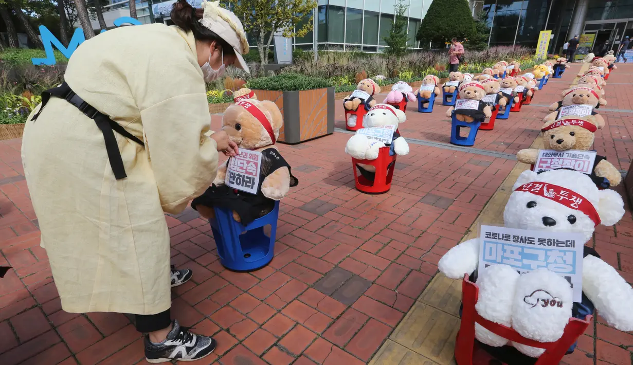 Pedagang kaki lima menempatkan boneka beruang untuk memprotes kekerasan terhadap PKL ilegal, di depan kantor distrik Mapo di Seoul, Kamis (24/9/2020). Boneka beruang itu menggantikan pengunjuk rasa untuk menghindari pelanggaran larangan aksi dengan lebih dari 10 orang. (AP Photo/Ahn Young-joon)