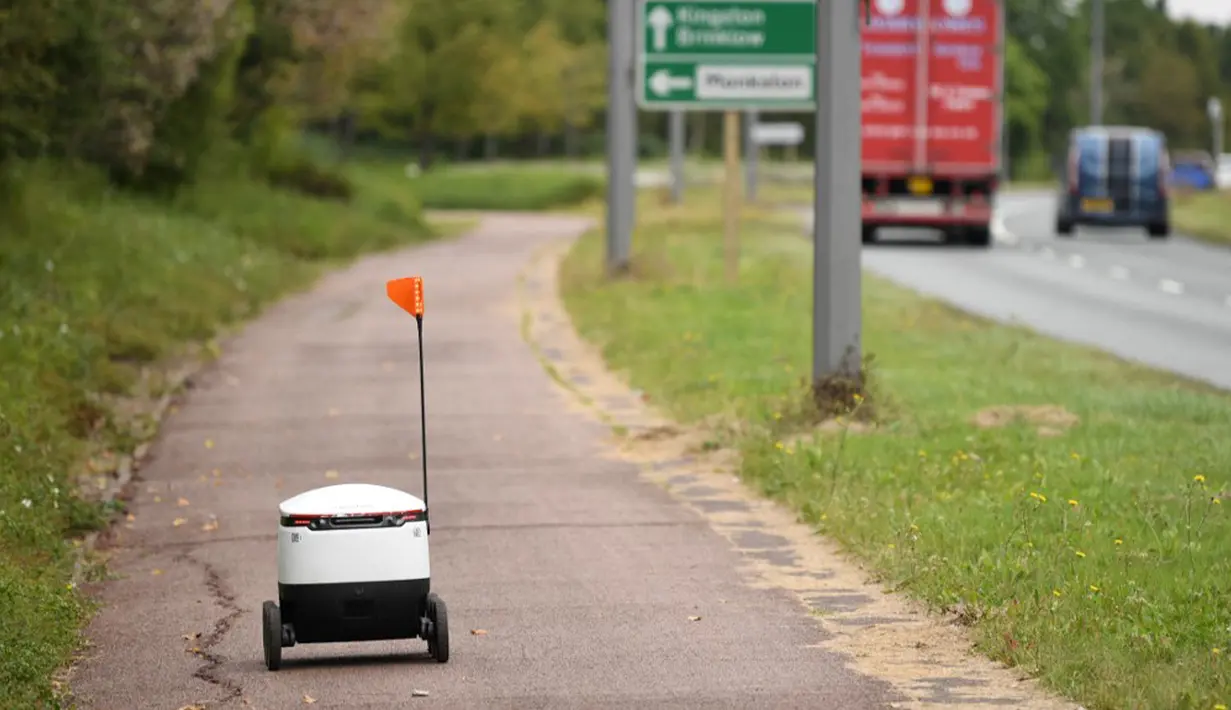 Robot otonom bernama Starship melakukan perjalanan untuk mengantarkan bahan makanan dari supermarket Co-op di Milton Keynes, Inggris, 20 September 2021. Robot Starship bertugas mengantarkan belanja dan makanan. (DANIEL LEAL-OLIVAS/AFP)