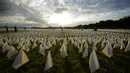 Warga melihat bendera putih untuk mengenang orang AS yang meninggal karena COVID-19 dalam instalasi seni sementara seniman Suzanne Brennan Firstenberg 'Di Amerika: Ingat' di National Mall, Washington, AS, Jumat (17/9/2021). Instalasi terdiri dari lebih dari 630.000 bendera. (AP Photo/Brynn Anderson)