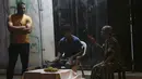 Seorang penjual anggur (tengah) menunggu pelanggan, sementara yang lain mengobrol dengannya selama penguncian yang diberlakukan selama pandemi virus corona, di kamp pengungsi Shati, di Kota Gaza, Selasa, (1/9/2020). (AP Photo/Adel Hana)