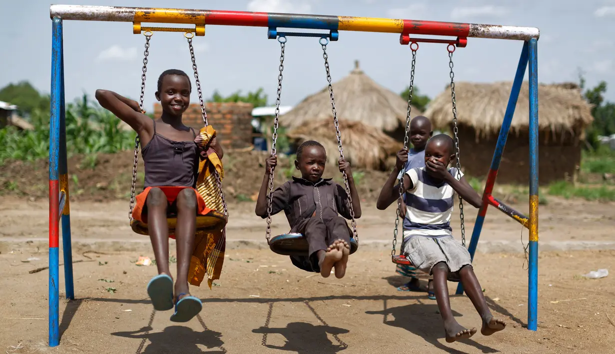 Anak-anak pengungsi Sudan Selatan bermain ayunan saat istirahat makan siang di halaman sekolah pembibitan Ombechi di Bidi Bidi, Uganda, (5/6). Puluhan ribu orang telah terbunuh akibat perang saudara tersebut. (AP Photo/Ben Curtis)