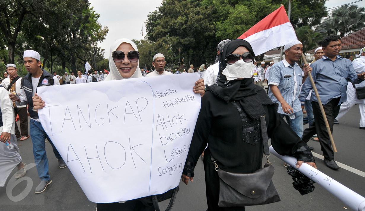 Demonstran perempuan menunjukkan spanduk saat aksi damai di Jalan Medan Merdeka Selatan, Jumat (4/11). Ratusan ribu massa aksi damai melakukan aksi menuntut penegakan hukum kasus dugaan penistaan agama. (Liputan6.com/Yoppy Renato)