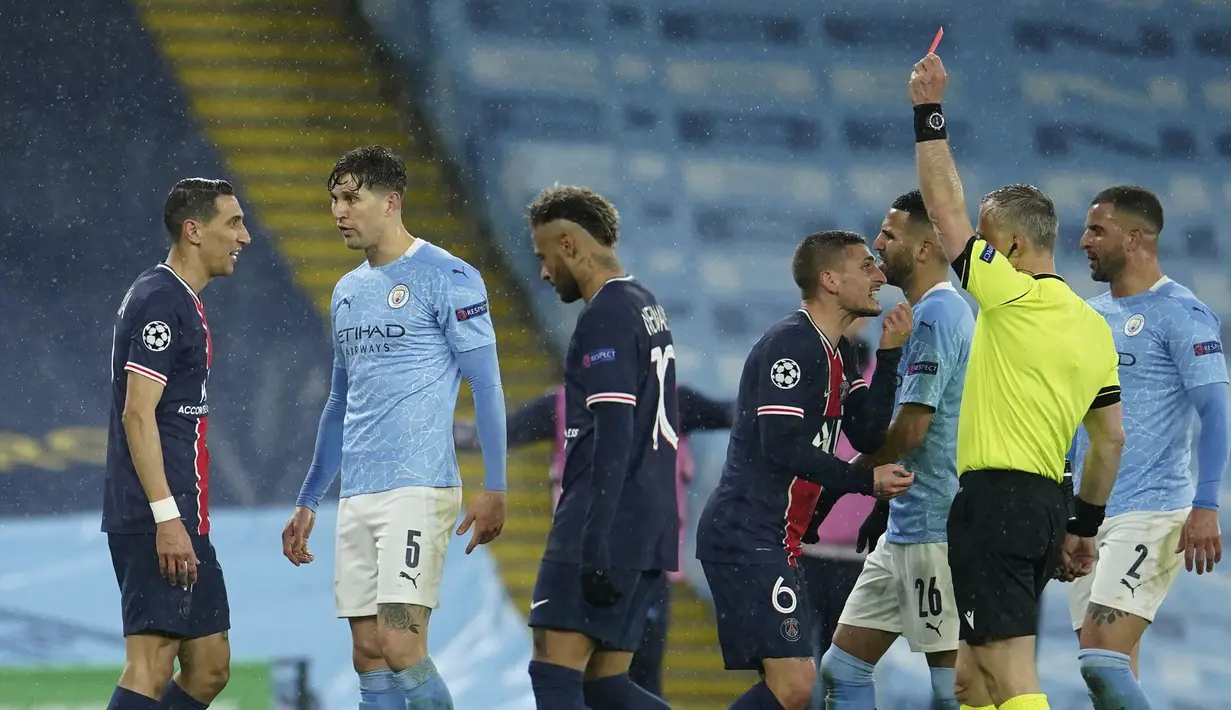 Gelandang Paris Saint-Germain, Angel Di Maria (kiri) menerima kartu merah dari wasit Bjorn Kuipers saat melawan Manchester City dalam laga leg kedua semifinal Liga Champions 2020/2021 di Etihad Stadium, Selasa (4/5/2021). PSG kalah 0-2 dari Manchester City. (AP/Dave Thompson)