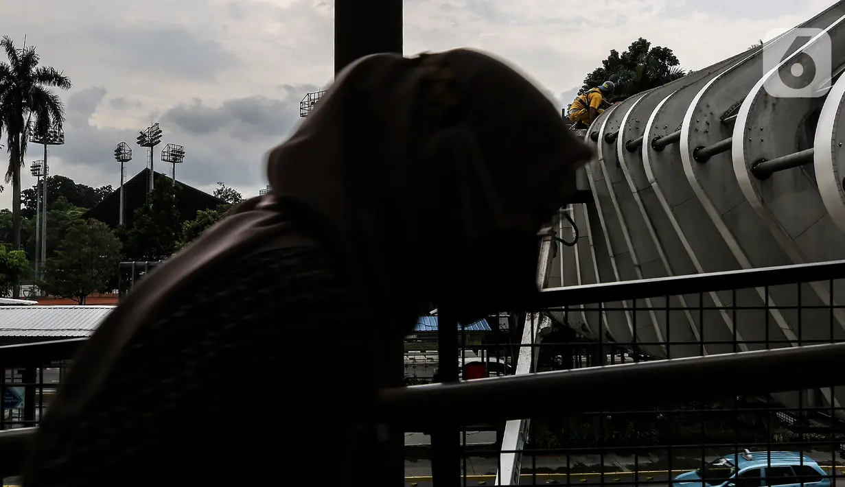 Aktivitas perawatan Jembatan Penyeberangan Orang (JPO) oleh pasukan kuning dari Dinas Bina Marga DKI Jakarta di Kawasan Sudirman, Senin (29/3/2021). Kegiatan tersebut dilakukan agar bersih terhidar dari debu serta para pemakai jembatan itu merasa aman dan nyaman. (Liputan6.com/Johan Tallo)
