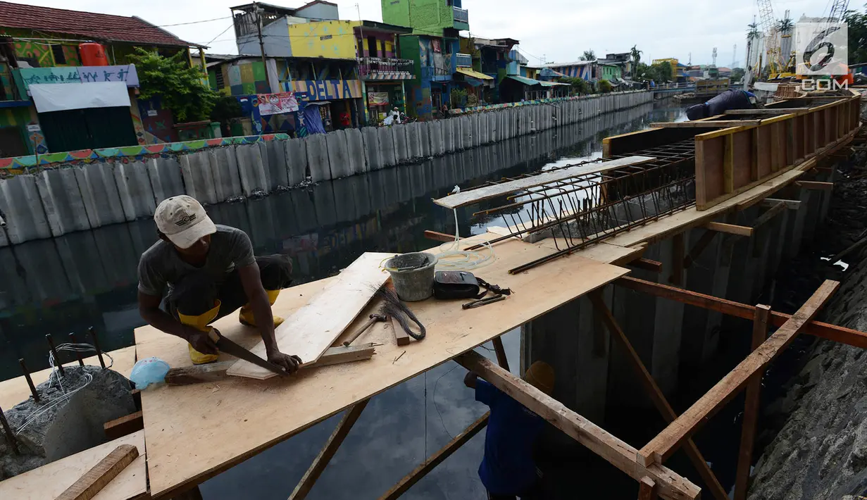 Pekerja melakukan pemasangan turap atau sheetpile Kali Item, Jakarta, Rabu (2/1). Turap sepanjang 1.900 meter pada sisi kanan dan kiri kali untuk mengantisipasi genangan dan banjir di kawasan tersebut pada musim hujan. (Merdeka.com/Imam Buhori)