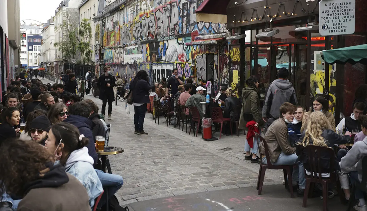 Pelanggan minum bir di teras kafe di Paris, Prancis, Rabu (19/5/2021). Prancis kembali membuka kafe dan restoran pada 19 Mei 2021 setelah ditutup lebih dari enam bulan karena pandemi virus corona COVID-19. (AP Photo/Lewis Joly)