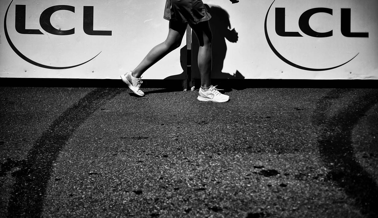 Bayangan seorang wanita melintasi bis peserta balap Tour de France pada etape kelima antara  Limoges dan Le Lioran, (6/7/2016). (AFP/Lionel Bonaventure)