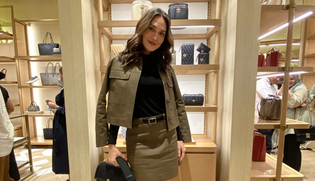 Melengkapi penampilan, Luna membawa hand bag warna hitam Tory Burch dipadukan sepatu boots warna serasi. [Anisha Saktian]