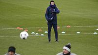 Pelatih PSG, Unai Emery melihat para pemainya berlatih di Saint-Germain-en-Laye, Prancis (13/2). PSG akan bertanding melawan Real Madrid pada babak 16 besar Liga Champions di Stadion Bernabeu, Spanyol. (AFP Photo/Lionel Bonaventure)