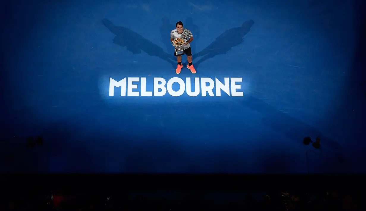Petenis asal Swiss Roger Federer, memegang trofinya setelah mengalahkan Rafael Nadal asal Spanyol pada Final Australia Terbuka 2017 di Melbourne, Minggu (29/1). Gelar ini merupakan gelar Grand Slam ke-18 sepanjang kariernya. (AP Photo/Andy Brownbill)