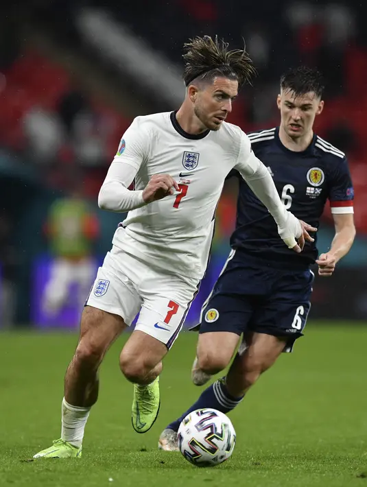 Gelandang Inggris, Jack Grealish membawa bola dari kawalan pemain Skotlandia, Kieran Tierney pada pertandingan grup D Euro 2020 di stadion Wembley, di London, Jumat (18/6/2021). Tambahan satu poin dari laga lawan Skotlandia membuat Inggris kini mengoleksi empat poin. (Justin Tallis/Pool via AP)