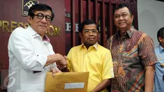 Menkumham, Yasonna H Laoly (kiri) menyerahkan SK Pengesahan Komposisi dan Personalia Pengurus DPP Partai Golkar 2014-2019 di Jakarta, Selasa (26/4/2016). SK diterima langsung Sekjen Partai Golkar Munas Bali, Idrus Marham. (Liputan6.com/Helmi Fithriansyah)