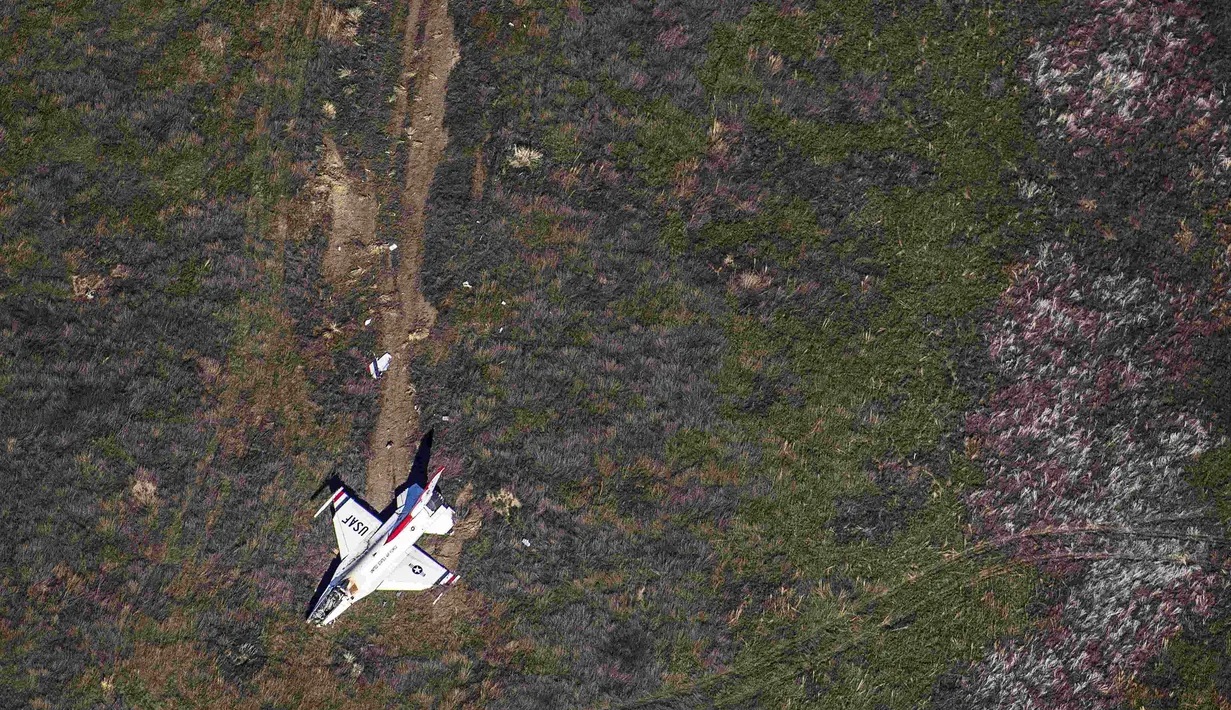 Pesawat  F-16 milik tim Thunderbirds Angkatan Udara AS jatuh di Colorado Springs setelah flyover di acara kelulusan Akademi Angkatan Udara, Kamis (2/6). Pilot Mayor Alex Turner yang mengemudikan pesawat selamat meski terluka. (Reuters/John Wark)