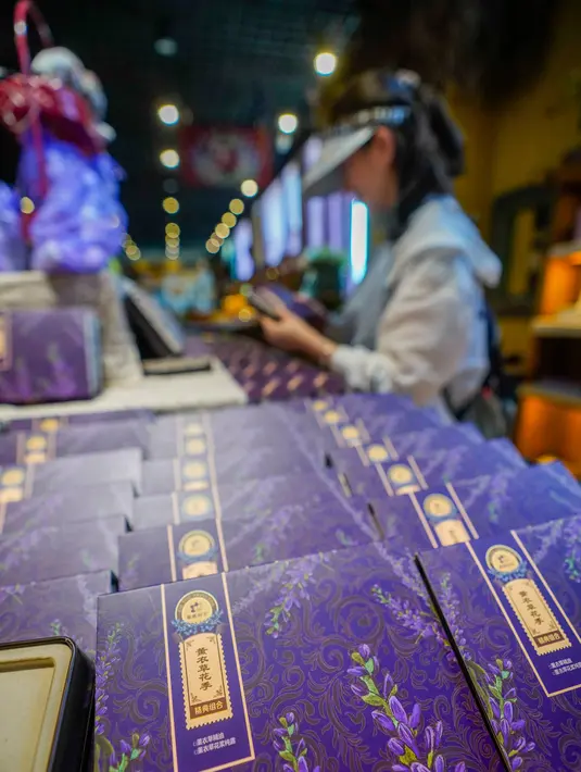 Seorang wisatawan memilih produk-produk olahan bunga lavender di sebuah perkebunan lavender di Wilayah Huocheng, Daerah Otonom Uighur Xinjiang, China barat laut (16/6/2020). (Xinhua/Zhao Ge)