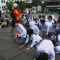 Puluhan siswa menyimak instruksi dari personel Badan Nasional Penanggulangan Bencana (BNPB) di Kawasan Kota Tua, Jakarta, Jumat (26/4/2024). (merdeka.com/Imam Buhori)