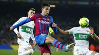 Gelandang Barcelona Nico Gonzalez berebut bola dengan bek Elche Diego Gonzalez pada jornada ke-18 Liga Spanyol di Stadion Camp Nou, Minggu (19/12/2021) dini hari WIB. Barcelona menang 3-2 atas Elche. (AP Photo/Joan Monfort)