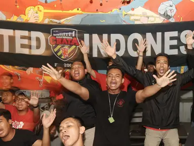 Kelompok suporter United Indonesia bernyanyi bersama saat acara Roaring Night Liga Inggris Manchester United vs Arsenal di Giardino Cafe, Kota Tangerang, Minggu (11/05/2024). (Bola.com/M Iqbal Ichsan)
