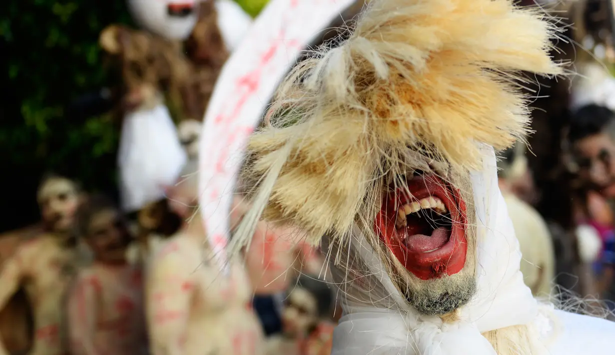 Peserta dengan memakai topeng bersuka ria mengikuti parade " La Calabiuza " di El Savador, Minggu (1/11/2015). " La Calabiuza " oleh warga Tonacatepeque diartikan sebagai Hari Kematian. (AFP PHOTO/Marvin RECINOS)