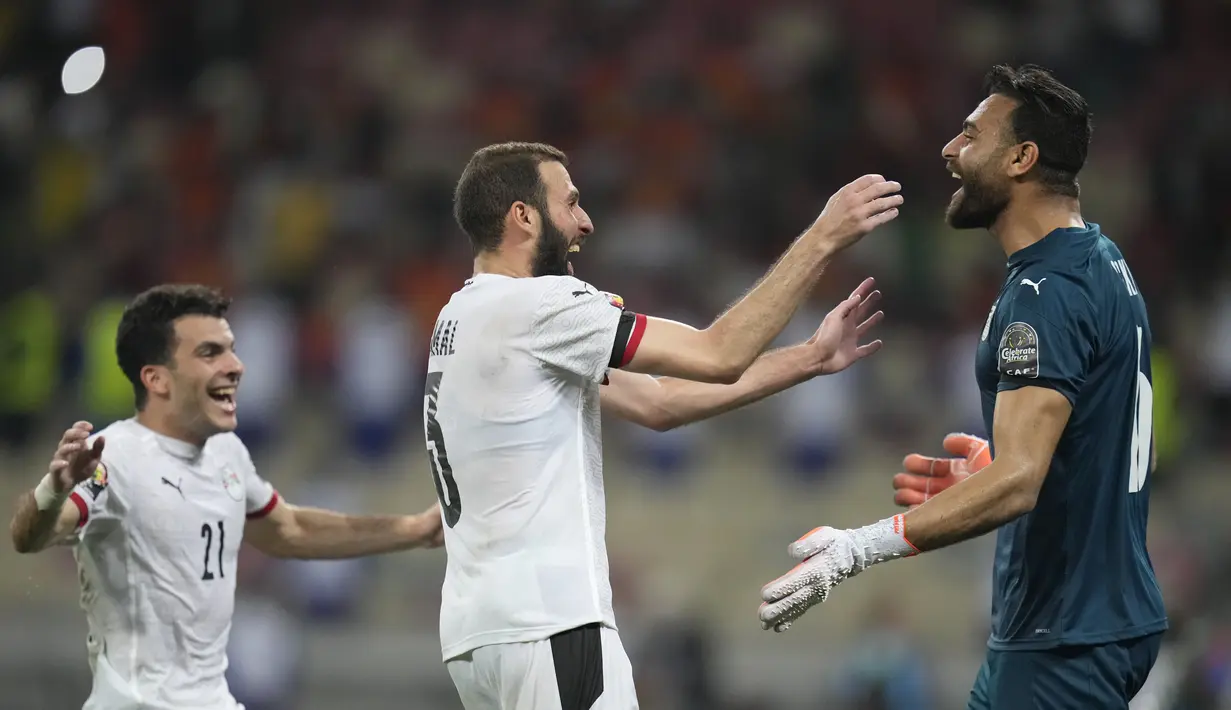 Para pemain Mesir merayakan dengan Mohamed Abou Gabal melawan Pantai Gading pada babak 16 besar Piala Afrika 2022 di Stade Omnisport de Douala, Rabu (26/1/2022). Mesir ke perempat final usai menyingkirkan Pantai Gading lewat drama adu penalti dengan skor 5-4 (0-0). (AP Photo/Themba Hadebe)
