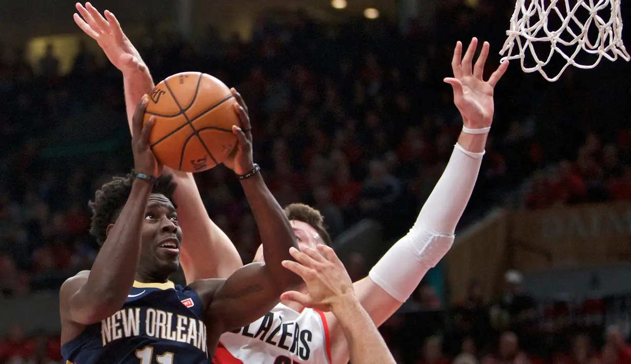 Pemain Pelicans, Jrue Holiday (kiri) berusaha melewati adangan pemain Blazers, Jusuf Nurkic pada laga Playoffs game ke-2 NBA basketball di Moda Center, Portland, (17/4/2018). Pelicans menang 111-102. (AP/Craig Mitchelldyer)