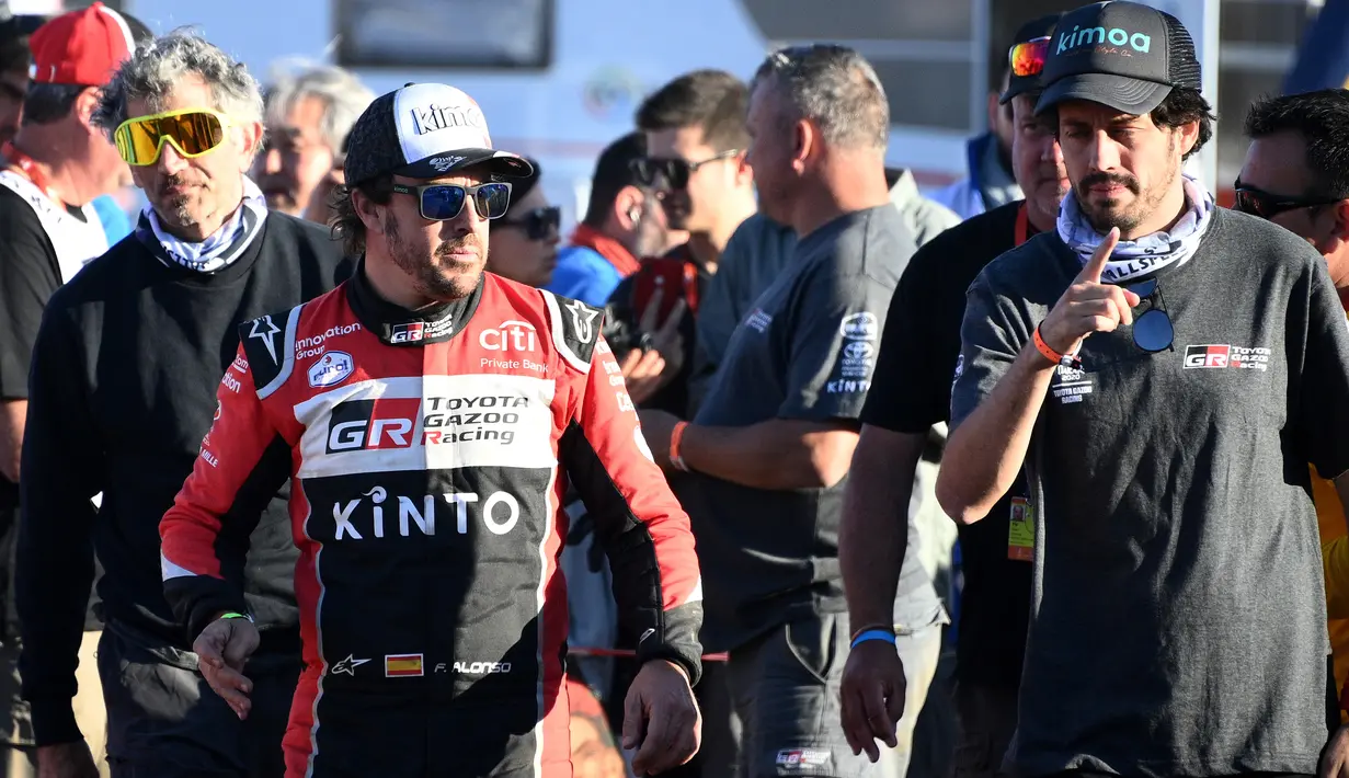 Pembalap Toyota Gazoo Racing Frenando Alonso (kedua kiri) berbincang dengan stafnya pada akhir stage kedua Reli Dakar 2020 antara Al Wajh dan Neom di Arab Saudi, Senin (6/1/2020). Dalam ajang ini Frenando Alonso dan Marc Coma mengendarai mobil pickup Toyota Hilux. (FRANCK FIFE/AFP)