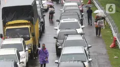 Sejumlah pedagang asongan menawarkan dagangan kepada pengendara di jalan tol Jagorawi yang sedang menanti waktu buka tutup jalur menuju kawasan wisata puncak, Bogor, Jawa Barat, Sabtu (31/10/2020). (Liputan6.com/Helmi Fithriansyah)